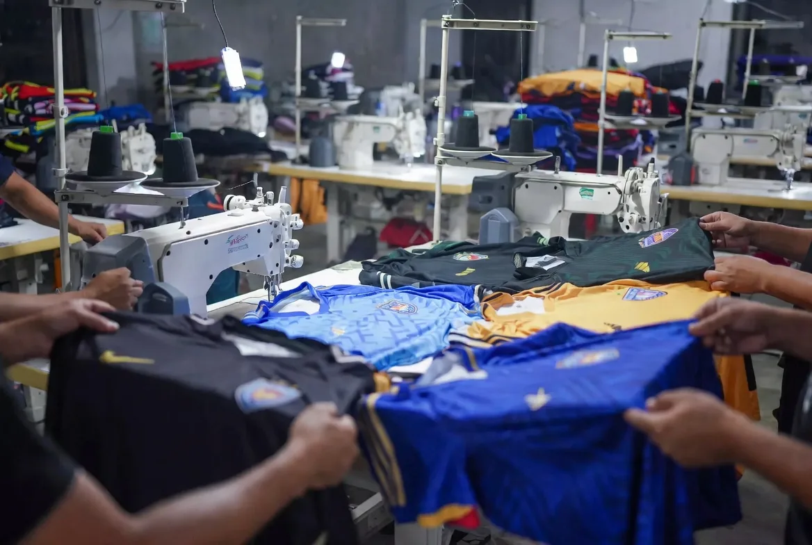 BWA Sports factory workers manufacturing custom soccer uniforms on industrial sewing machines