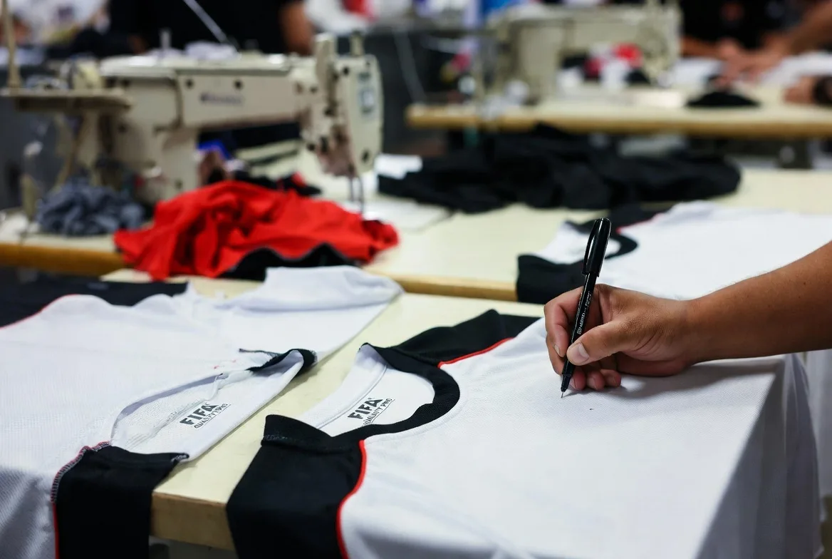 BWA Sports designer creating a custom soccer jersey design with pencil on white shirt